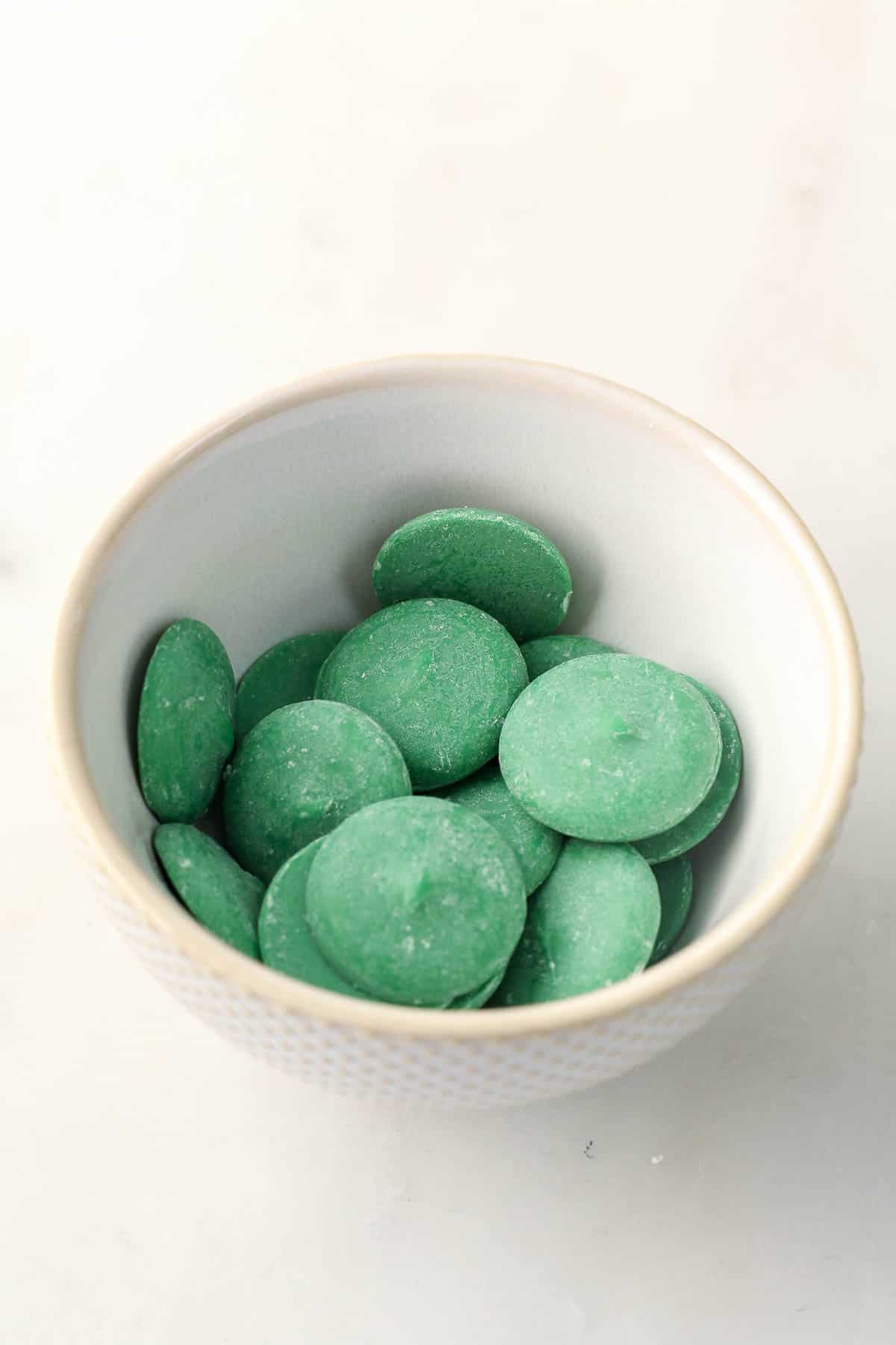 Green candy melts in a white bowl.