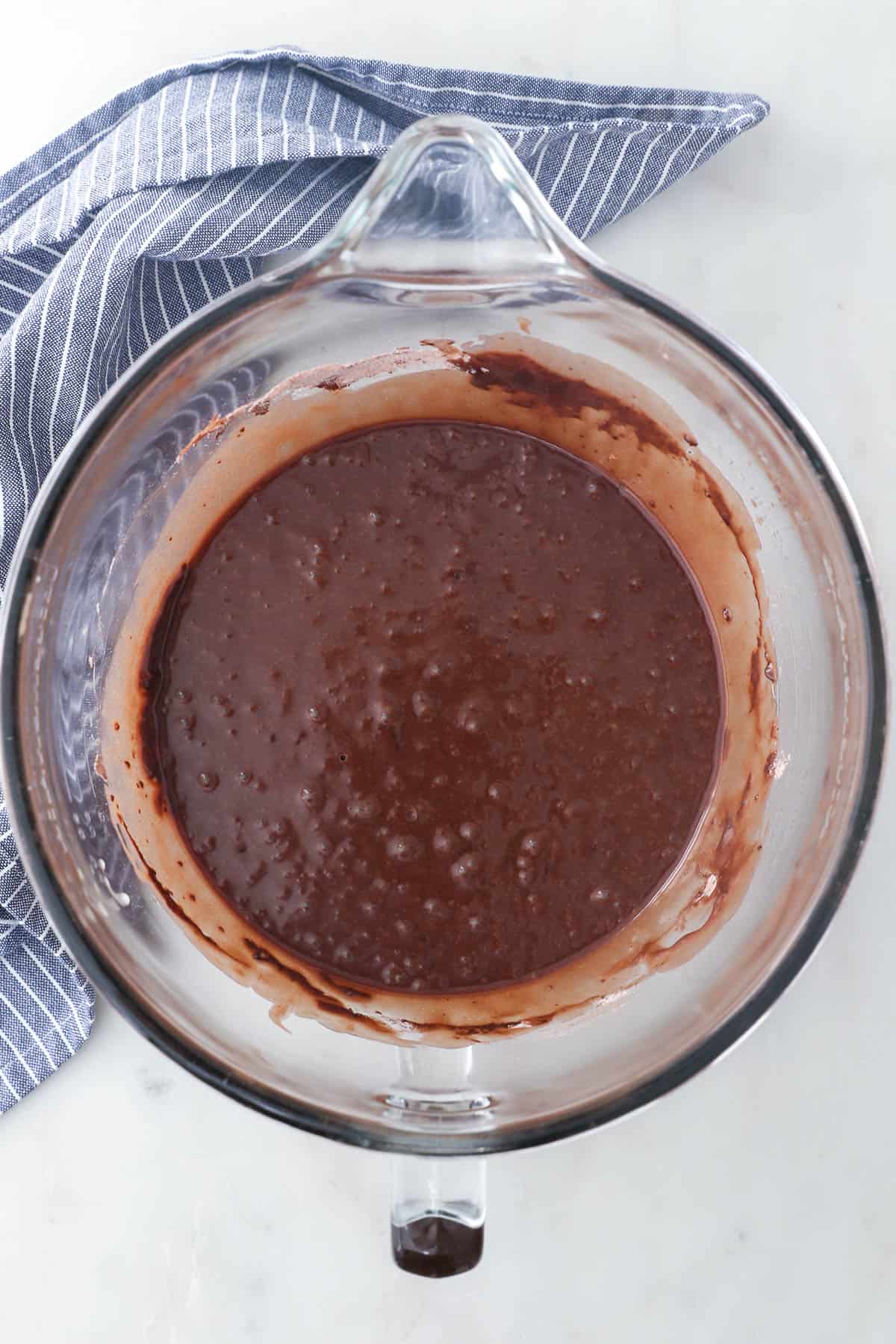 Chocolate rum cake batter in a glass mixing bowl.