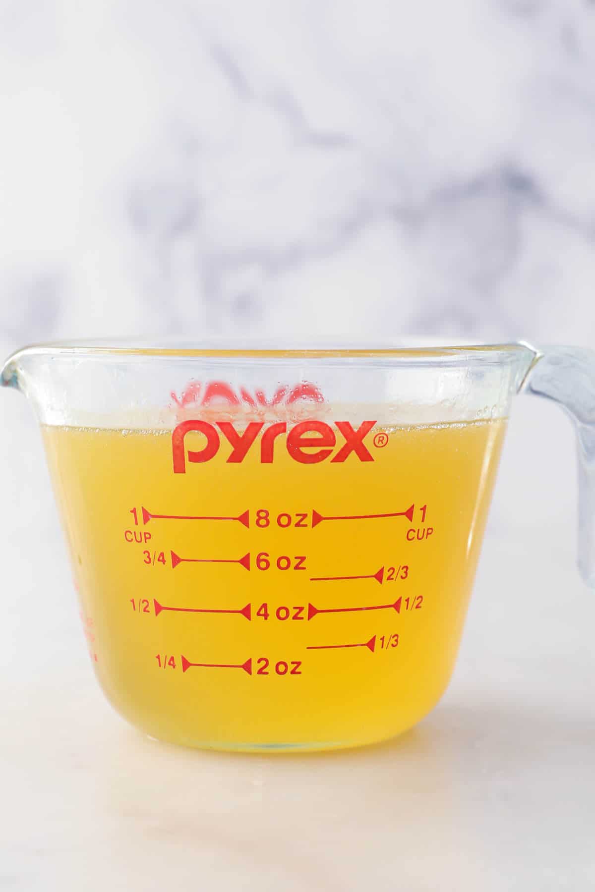 a glass measuring cup with a rum glaze