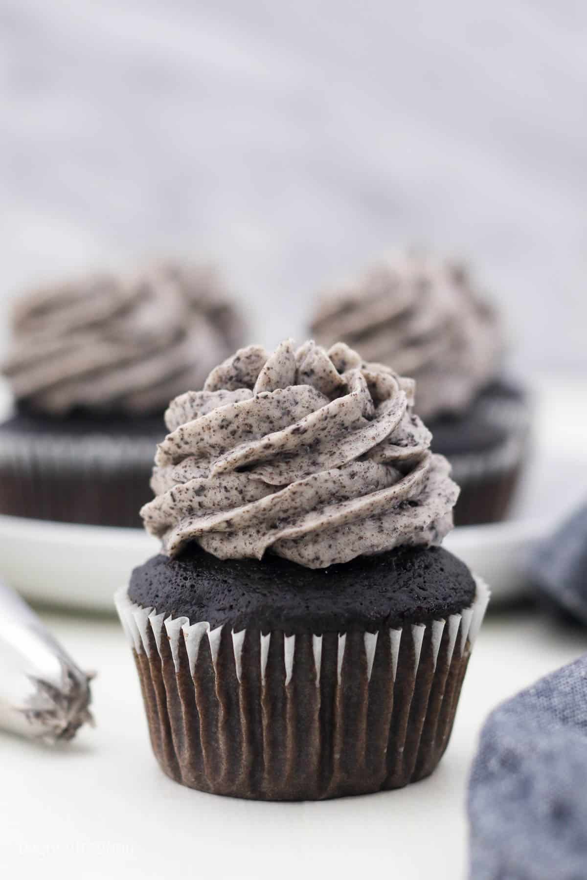 side view of a chocolate cupcake topped with frosting
