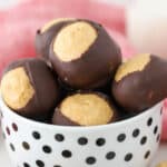 A small white bowl with black polkadots filled with Peanut butter buckeyes