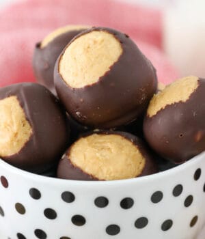 A small white bowl with black polkadots filled with Peanut butter buckeyes