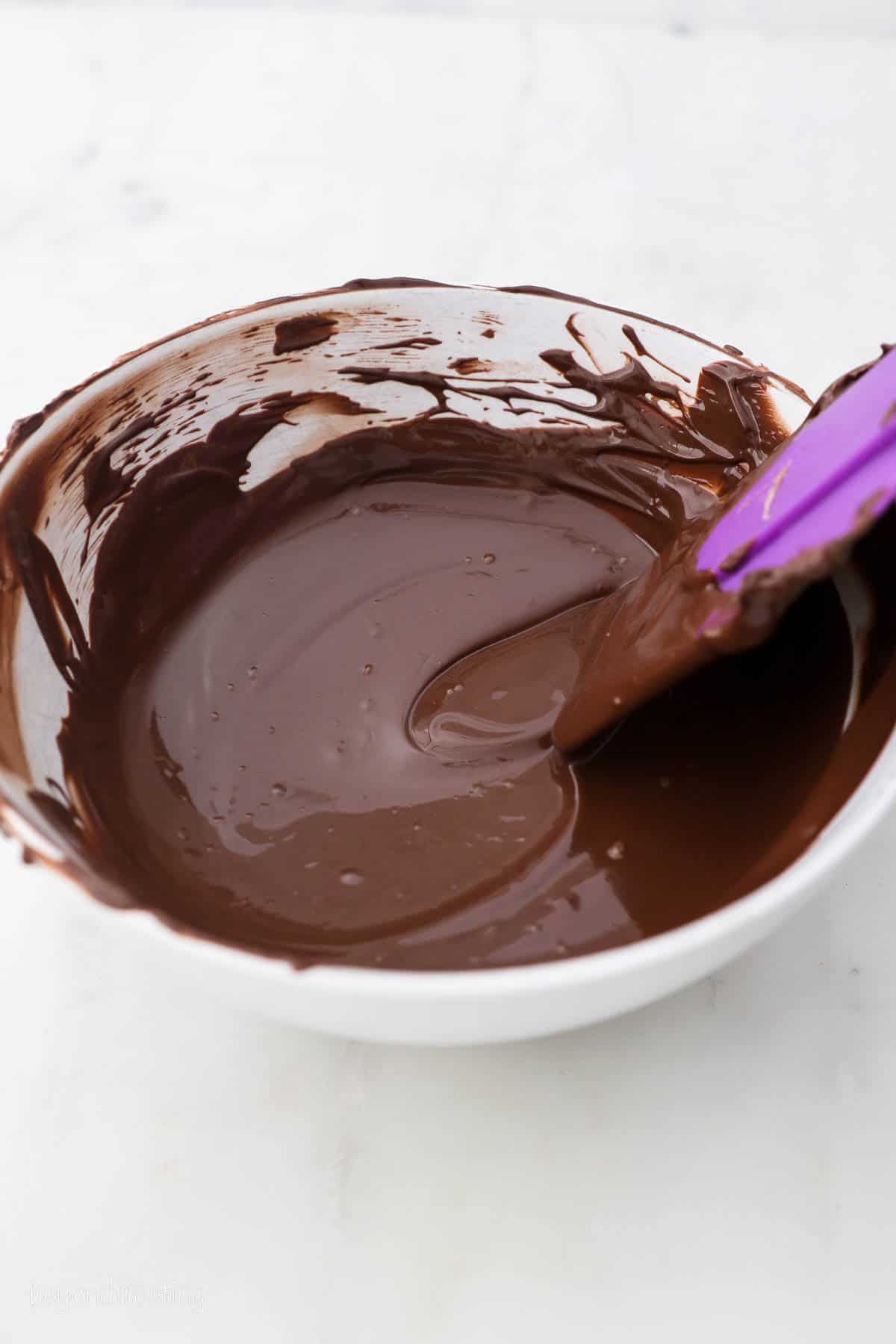 A Bowl of Melted Chocolate with a spatula resting on the side of the bowl