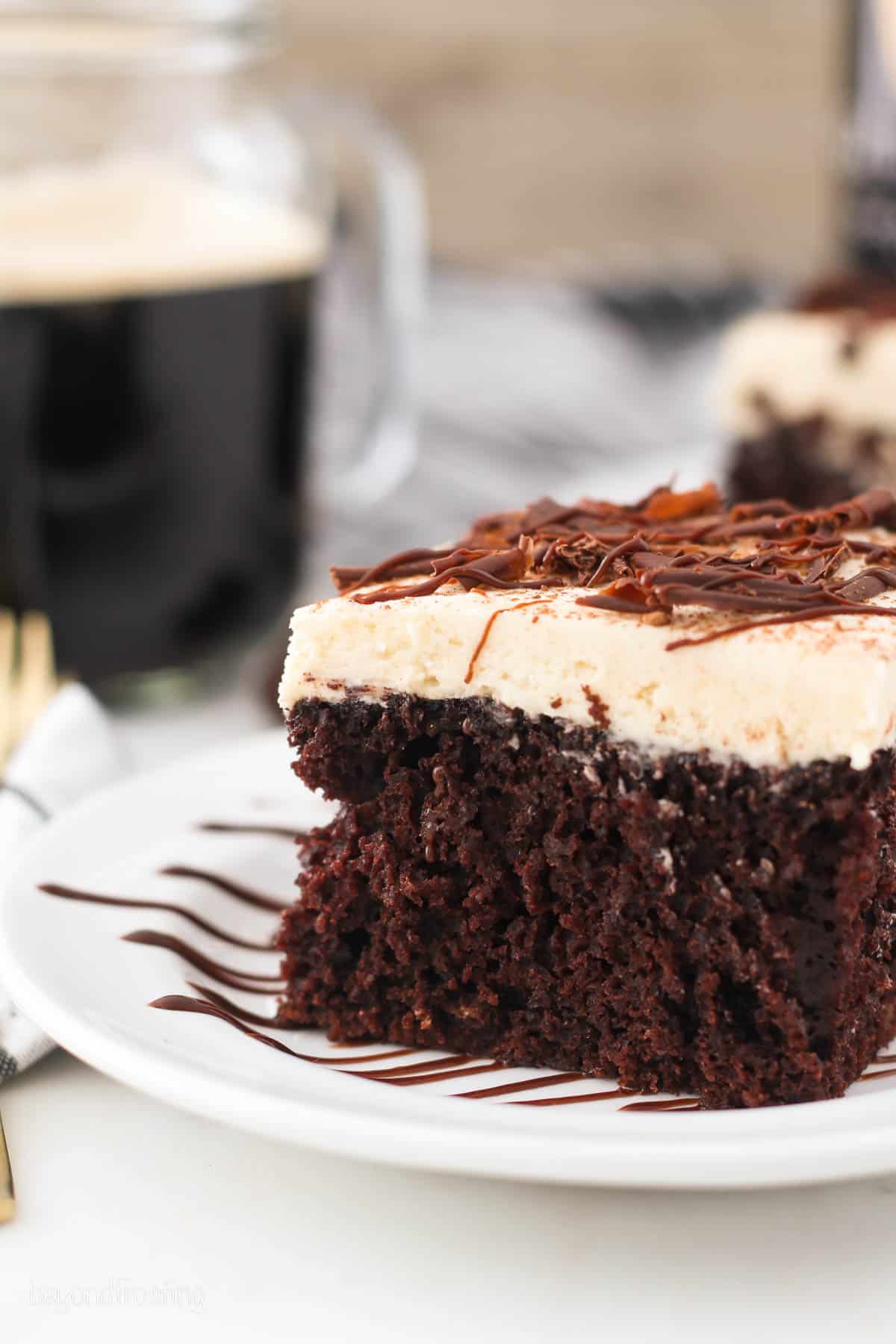 side view of a piece of chocolate cake topped with frosting and chocolate.