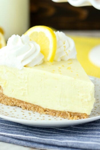 side view of a slice of lemon pie topped with whip and a lemon slice.