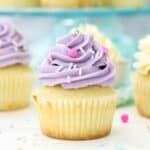 Vanilla cupcakes frosted with purple Swiss meringue buttercream frosting and sprinkles