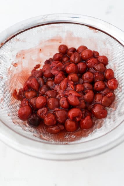 a bowl with cherries strained out of pie filling