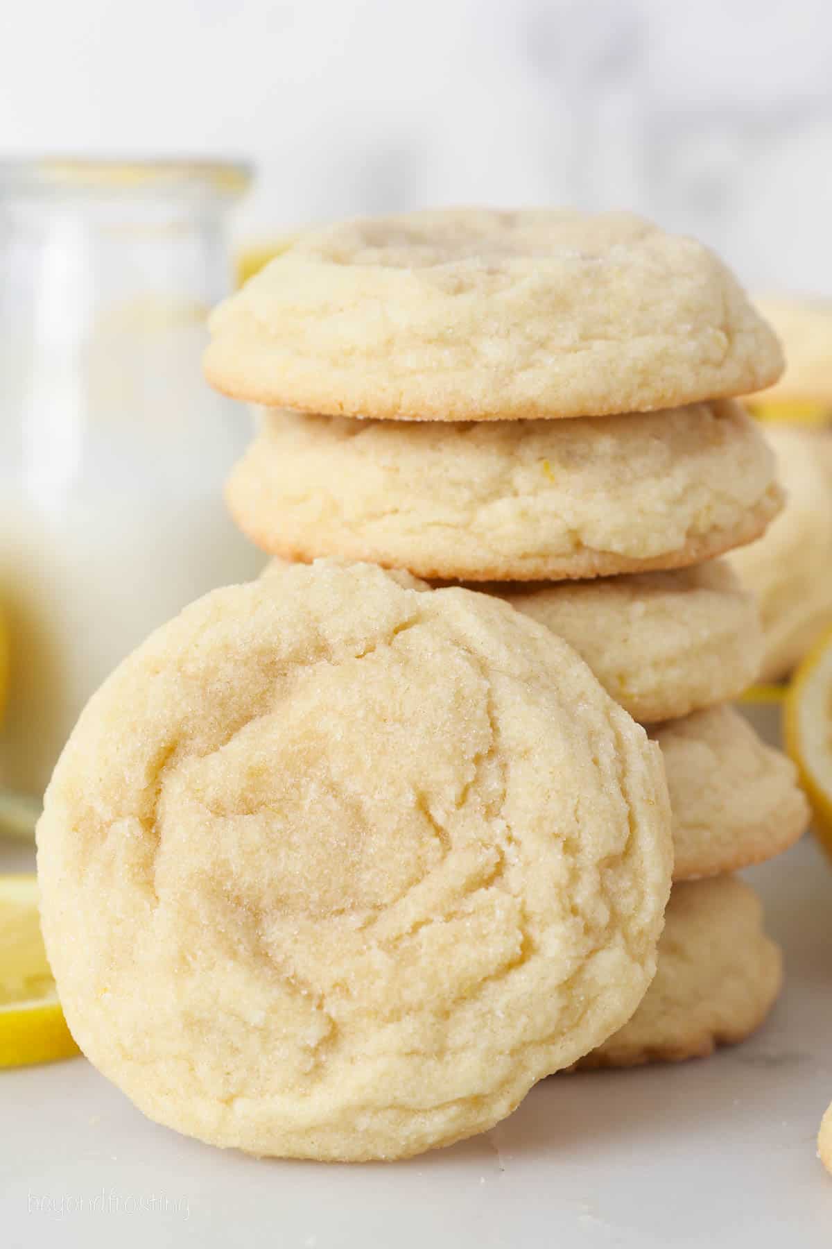 A lemon sugar cookie leaning against a stack of cookies.