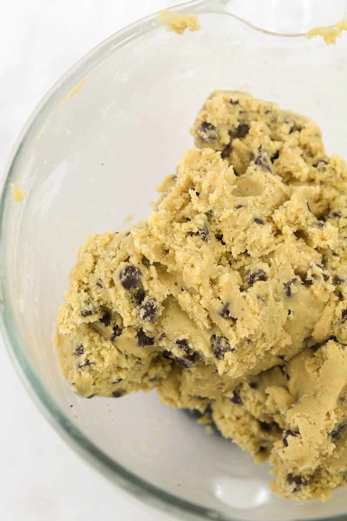 Chocolate chip cookie dough in a large glass bowl.