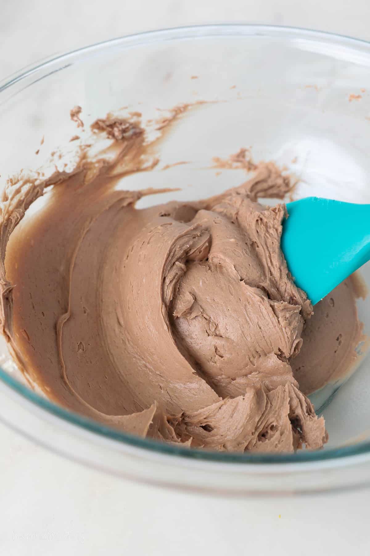 This chocolate mousse cake recipe is easy to make, with layers of moist chocolate cake, fluffy chocolate mousse, and creamy chocolate ganache. Chocolate whipped cream in a bowl.