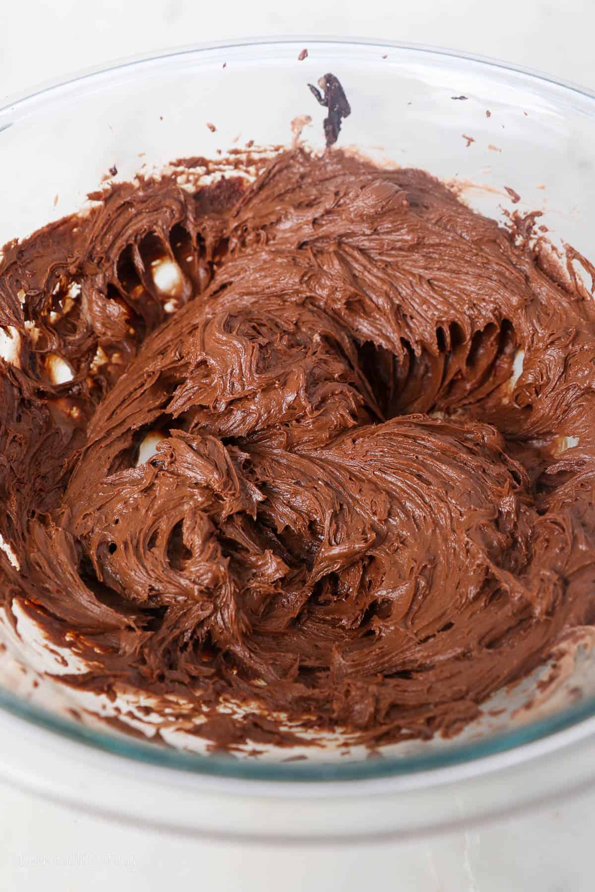 This chocolate mousse cake recipe is easy to make, with layers of moist chocolate cake, fluffy chocolate mousse, and creamy chocolate ganache. Chocolate cream cheese mixture in a bowl.