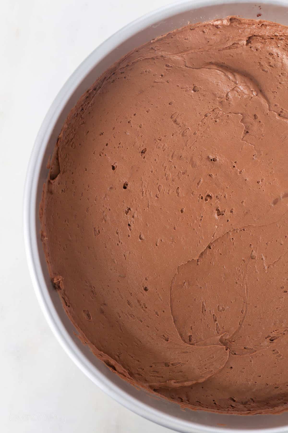 This chocolate mousse cake recipe is easy to make, with layers of moist chocolate cake, fluffy chocolate mousse, and creamy chocolate ganache. Chocolate mousse spread over the cake layer in a springform pan.