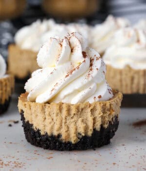 A unwrapped mini coffee cheesecake topped with whipped cream