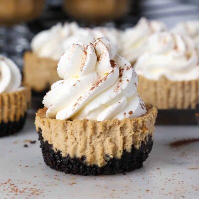 A unwrapped mini coffee cheesecake topped with whipped cream