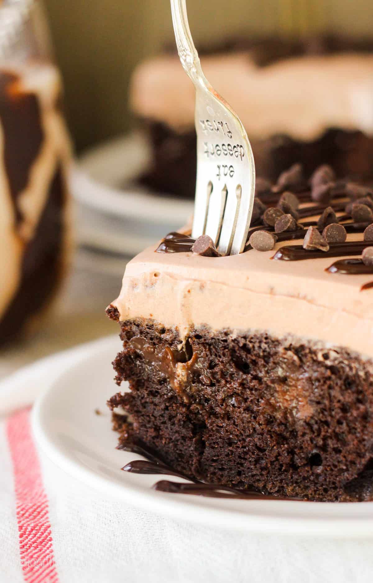 a fork being plunged into a slice of mudslide poke cake.