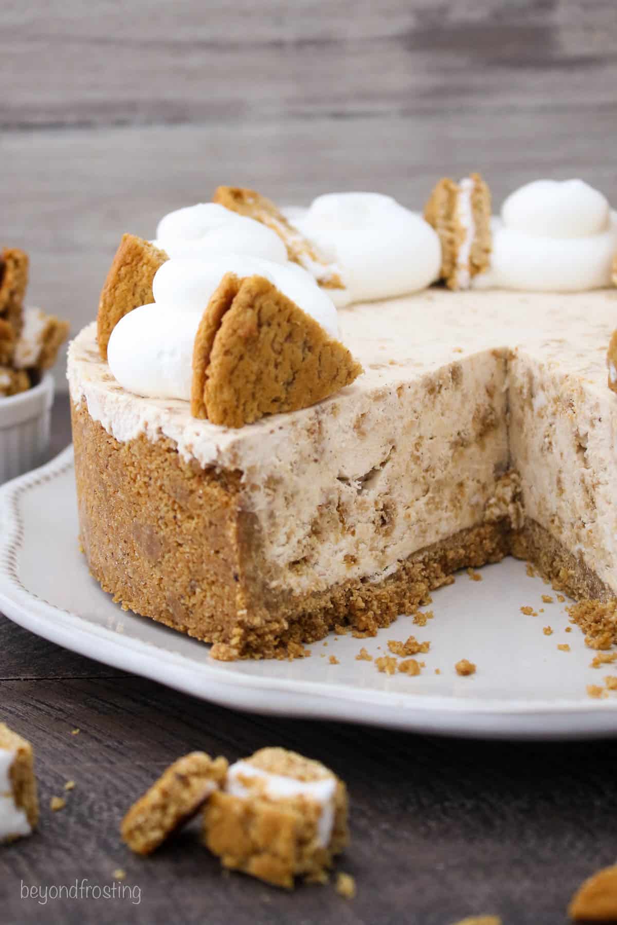a whole ice cream pie topped with oatmeal cream pies and whipped cream with a slice cut out.