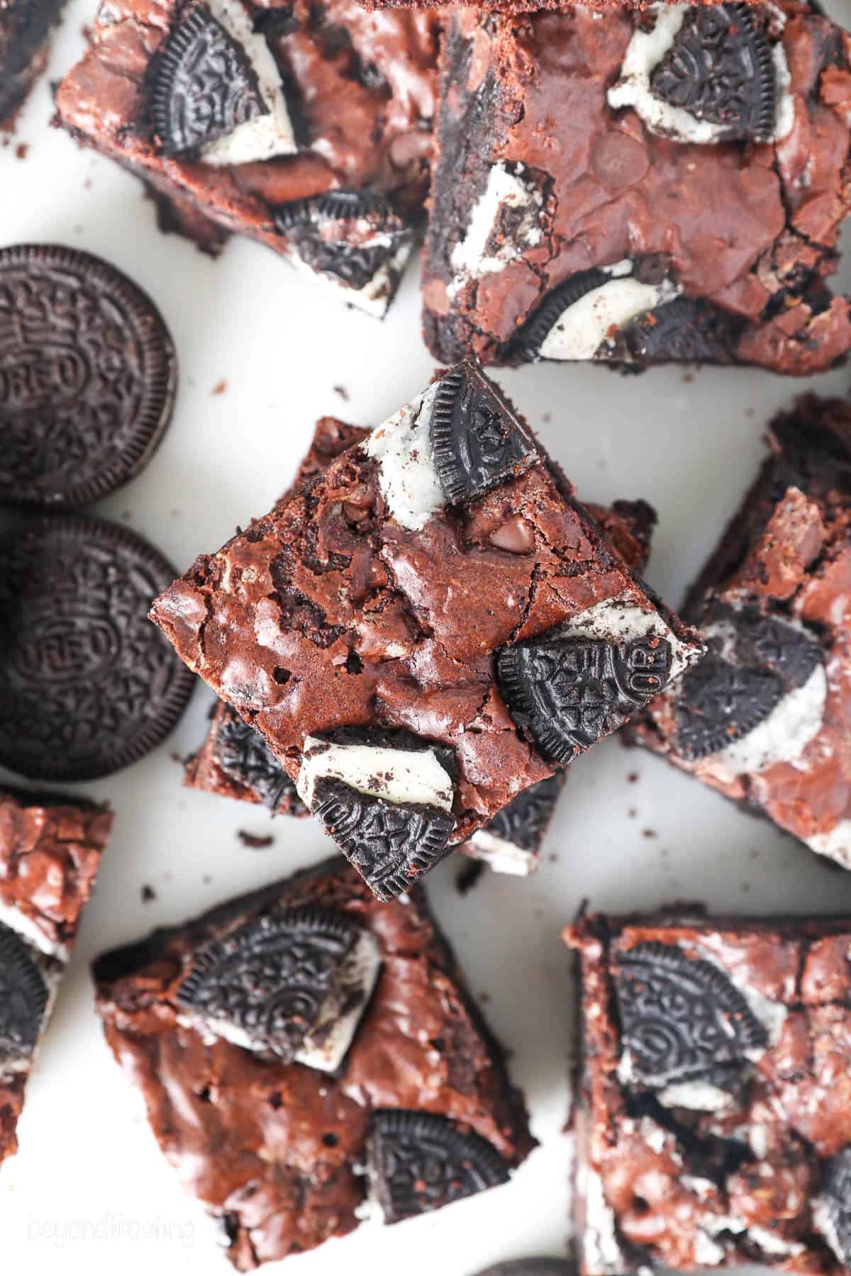 Overhead view of assorted Oreo brownies on a white surface.