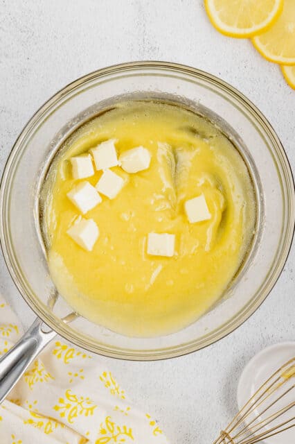 Cubes of butter added to lemon curd in a double boiler.