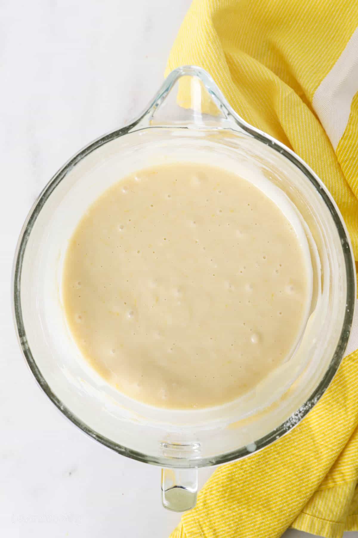 Lemon cake batter in a glass mixing bowl.