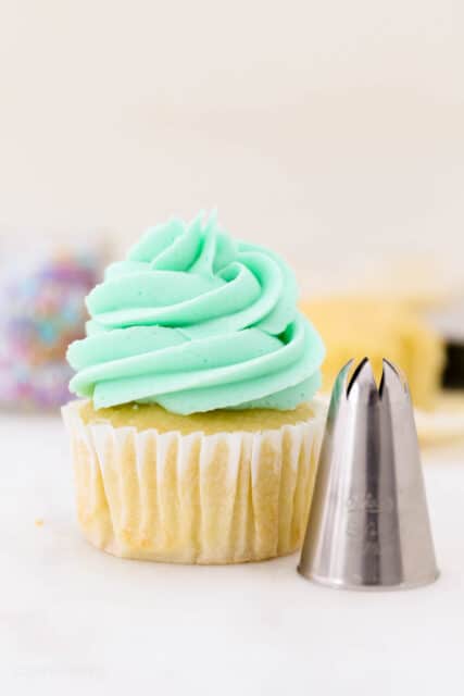 A cupcake frosted with a swirl of teal buttercream piped from am Ateco 849 piping tip.