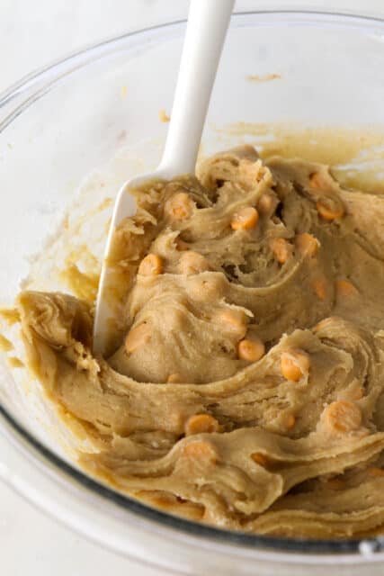 A mixing bowl with batter for blondie bars with butterscotch chips