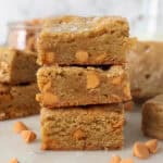 A stack of three brown butter blondies with butterscotch chips and sea salt