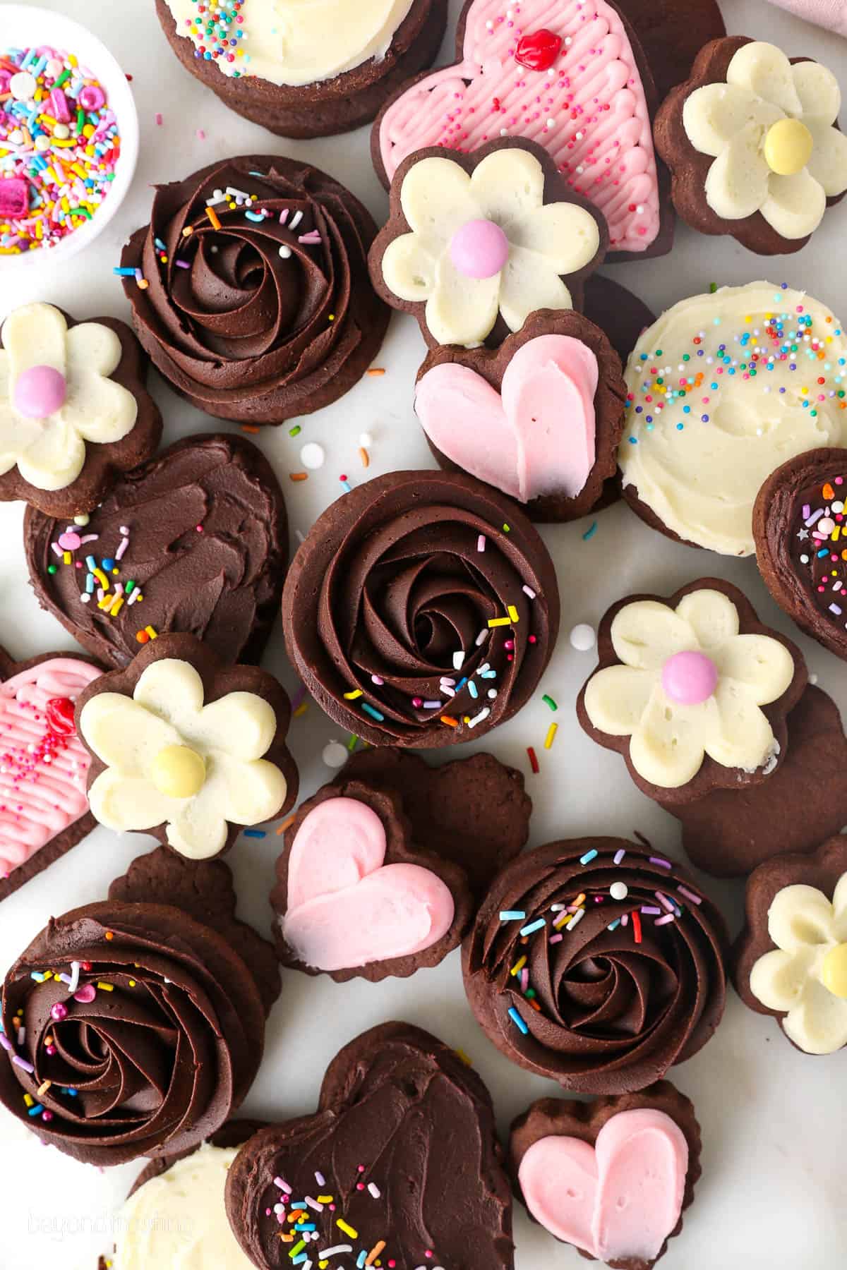 Overhead view of chocolate cutout sugar cookies frosted and decorated with various designs and buttercream colors.