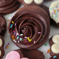 Close up overhead view of chocolate cutout sugar cookies frosted and decorated with various designs and buttercream colors.