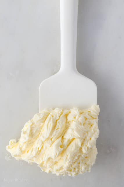 Homemade buttercream frosting on the end of a white spatula.