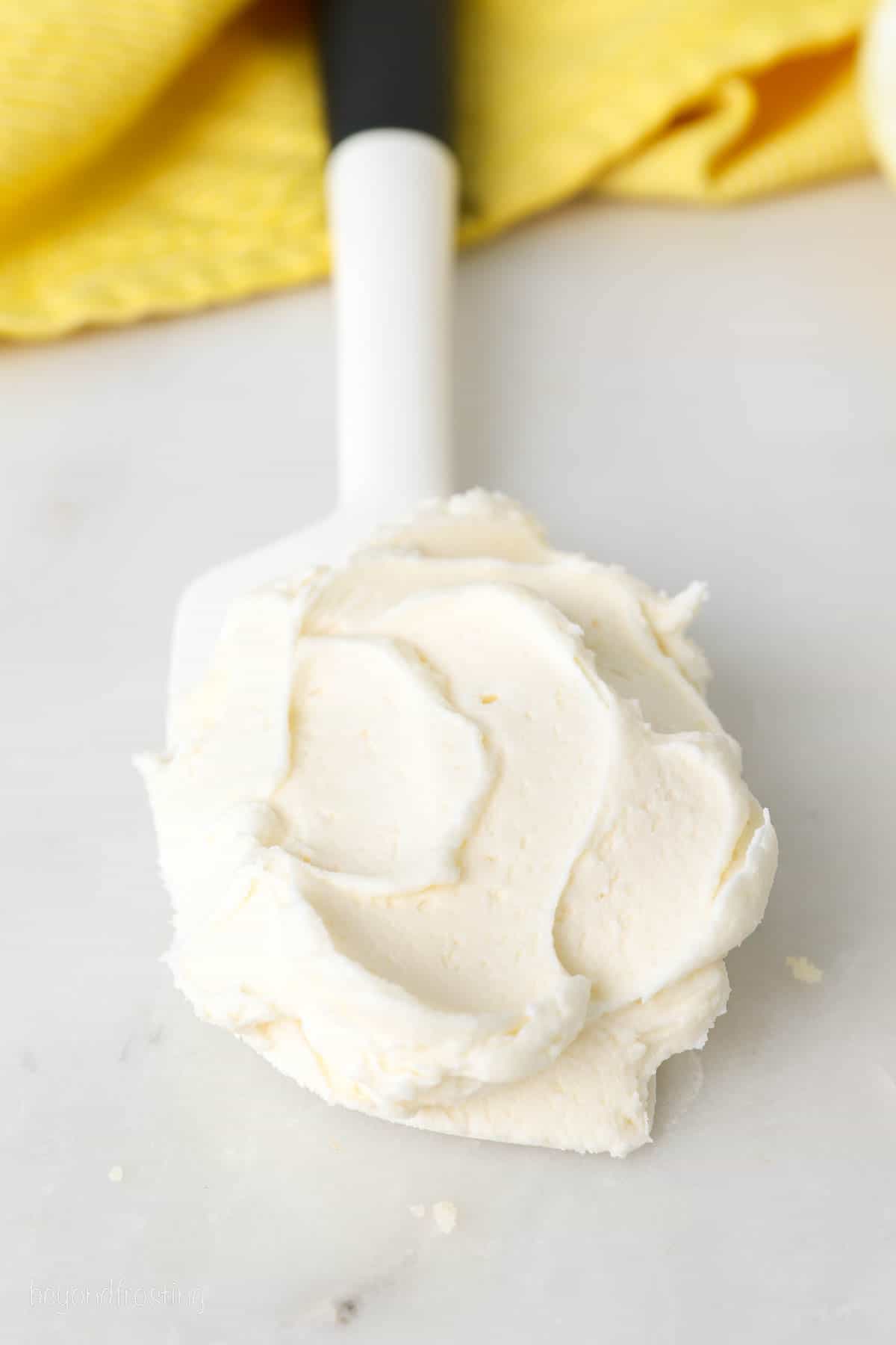a white spatula swirled with vanilla buttercream