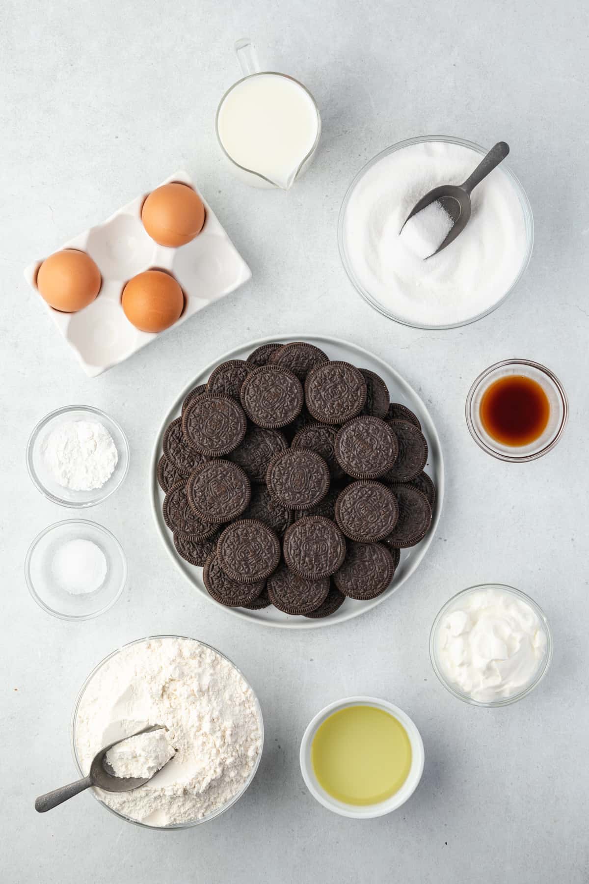 Ingredients for Oreo Cupcakes laid out on a table in various small bowls and dishes