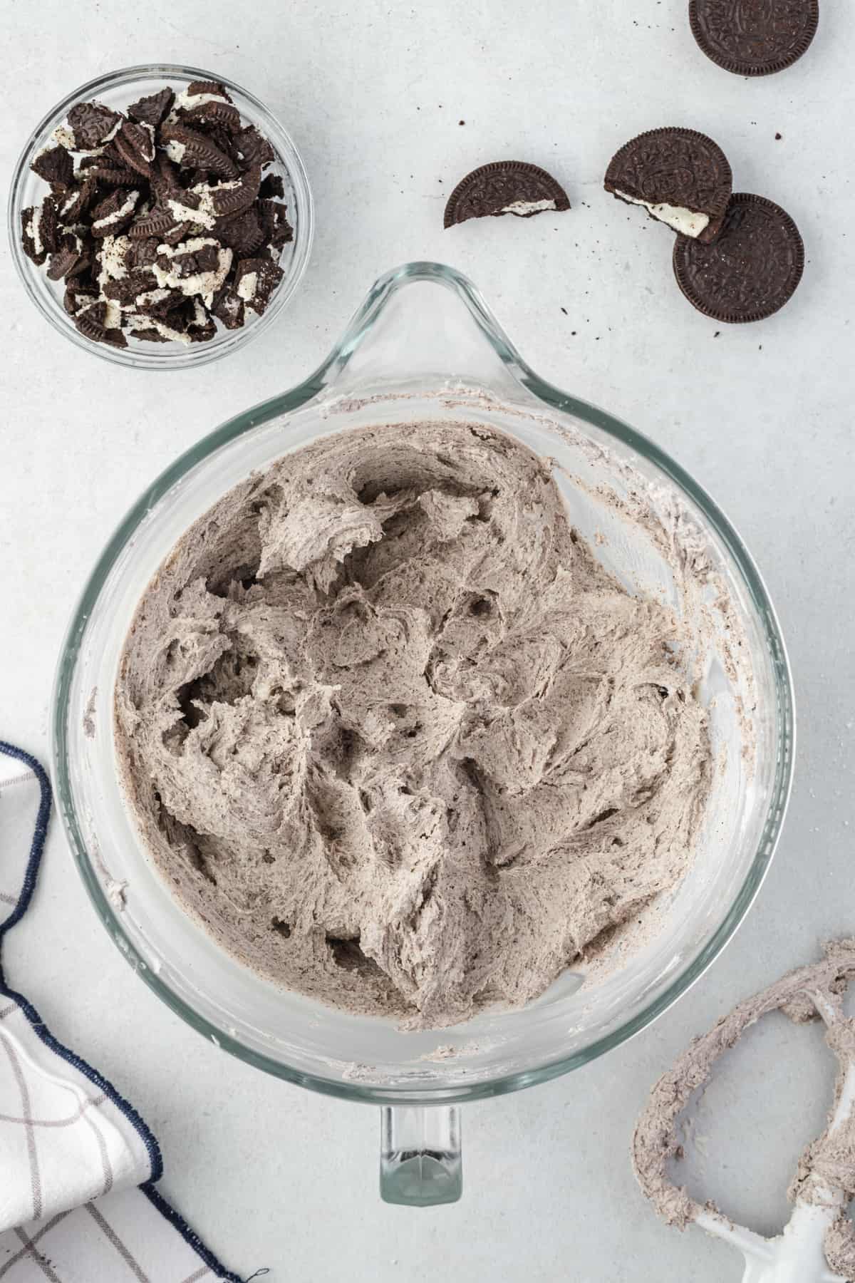 a glass mixing bowl with Oreo buttercream