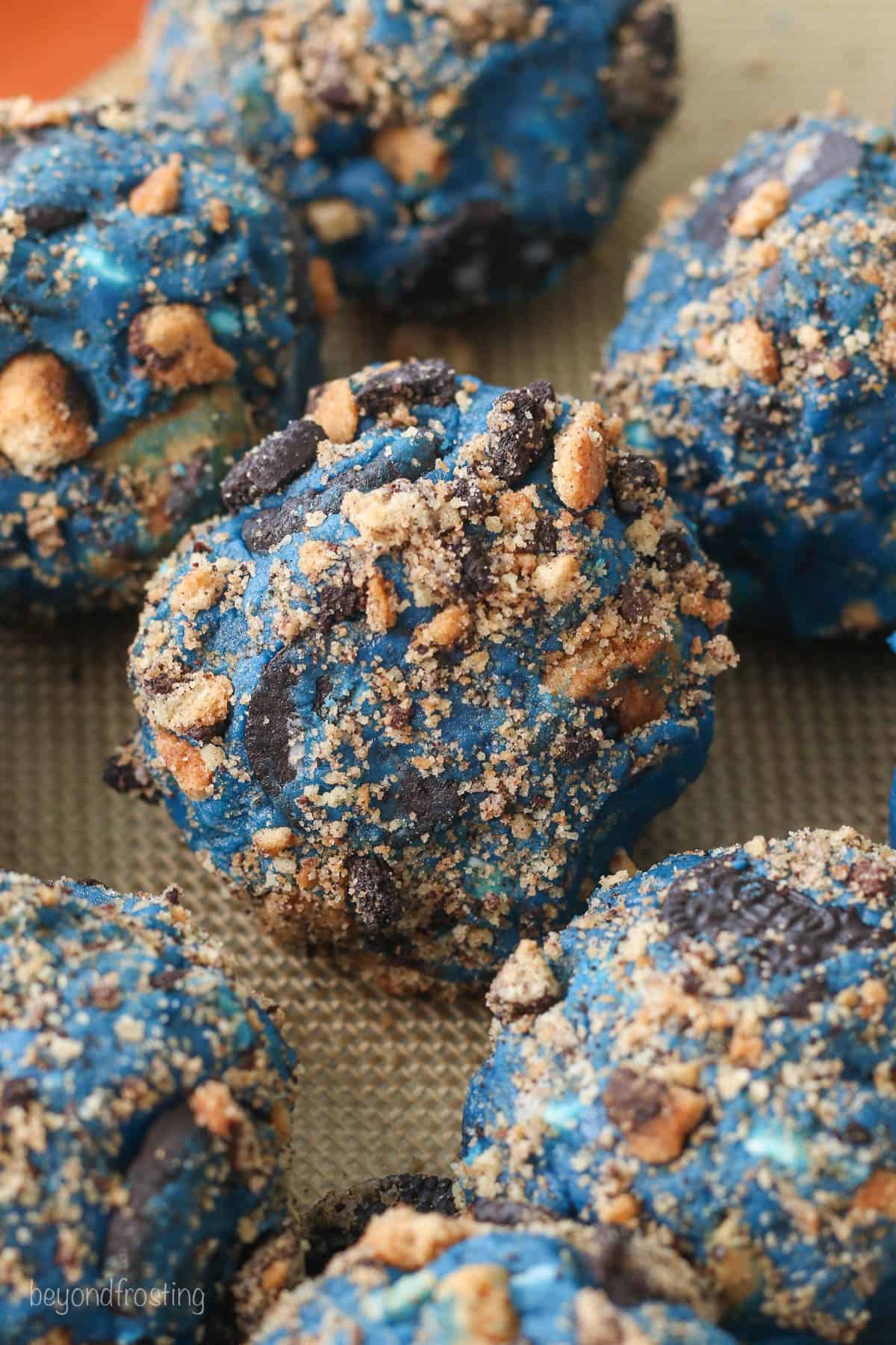 Close up of rolled Cookie Monster cookie dough balls rolled in cookie crumbs.