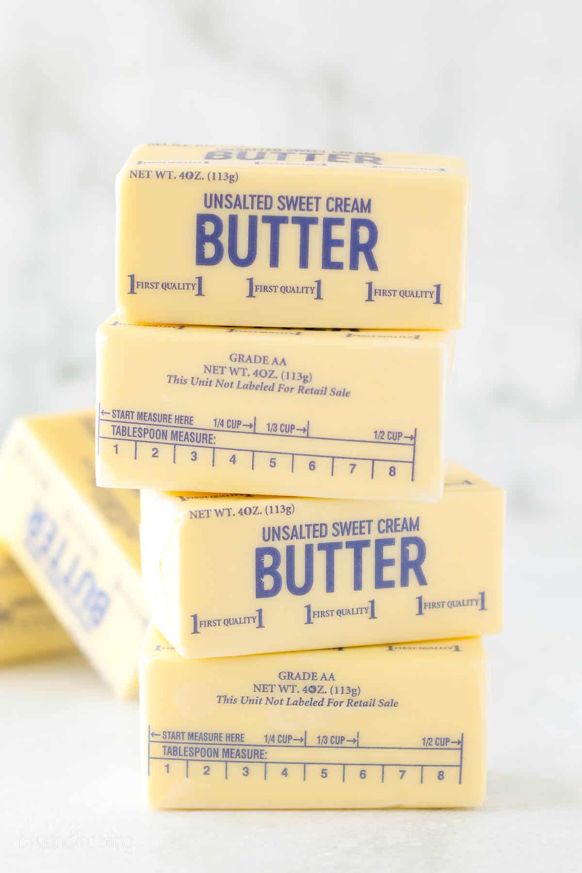 Bricks of butter stacked on top of one another on a countertop.