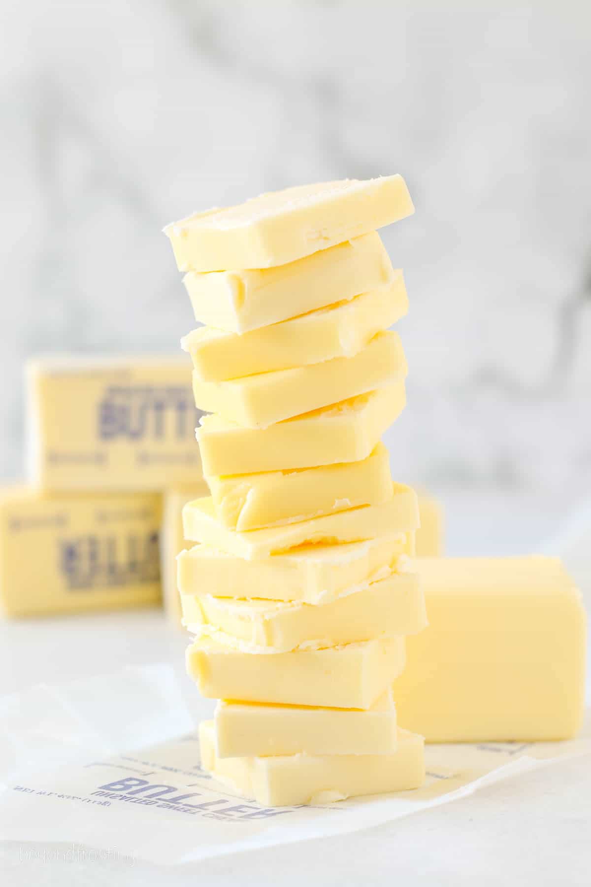 Sliced butter stacked in a small tower on a countertop.