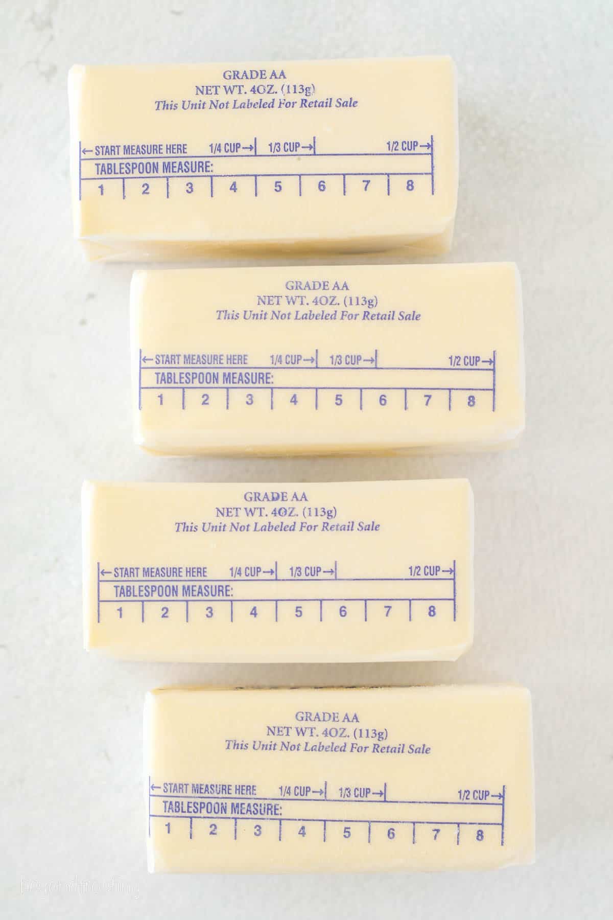 Butter sticks on a countertop, showing the measuring marks.