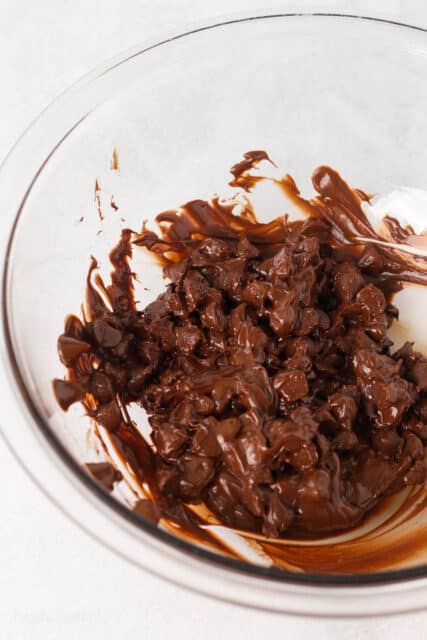 Partially melted chocolate chips in a glass bowl.