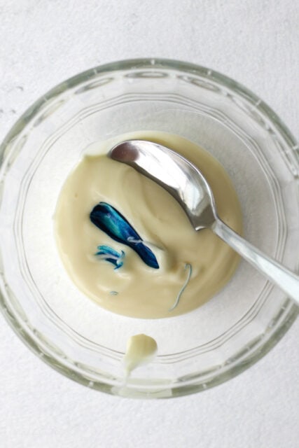 Blue gel dye added to a bowl of melted white chocolate.