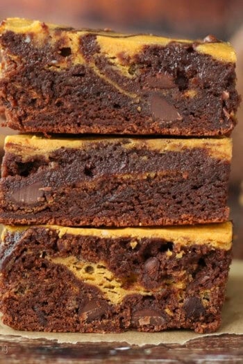 Three pumpkin swirl brownies stacked on top of one another.