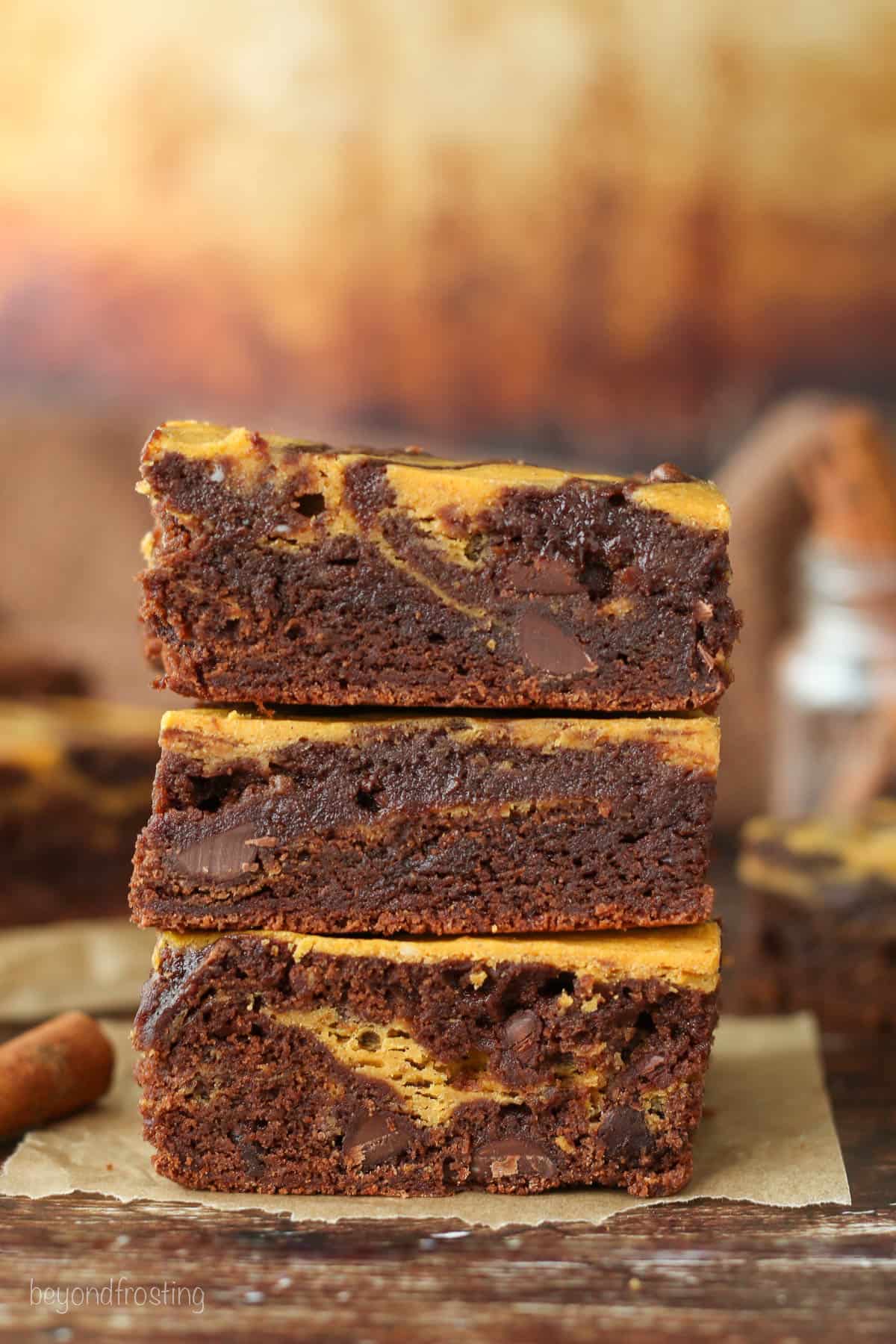 Three pumpkin swirl brownies stacked on top of one another.