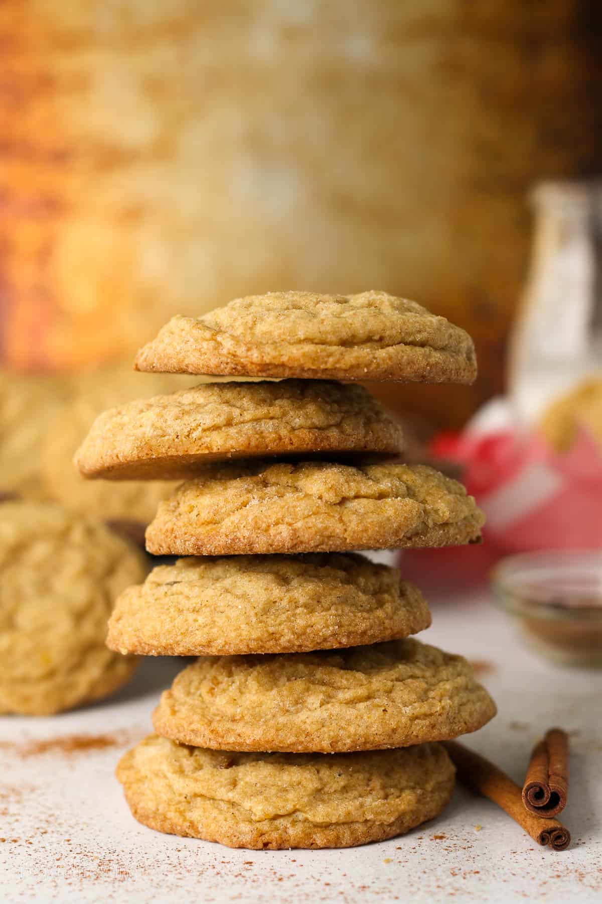 A tall stack of pumpkin sugar cookies on a countertop.