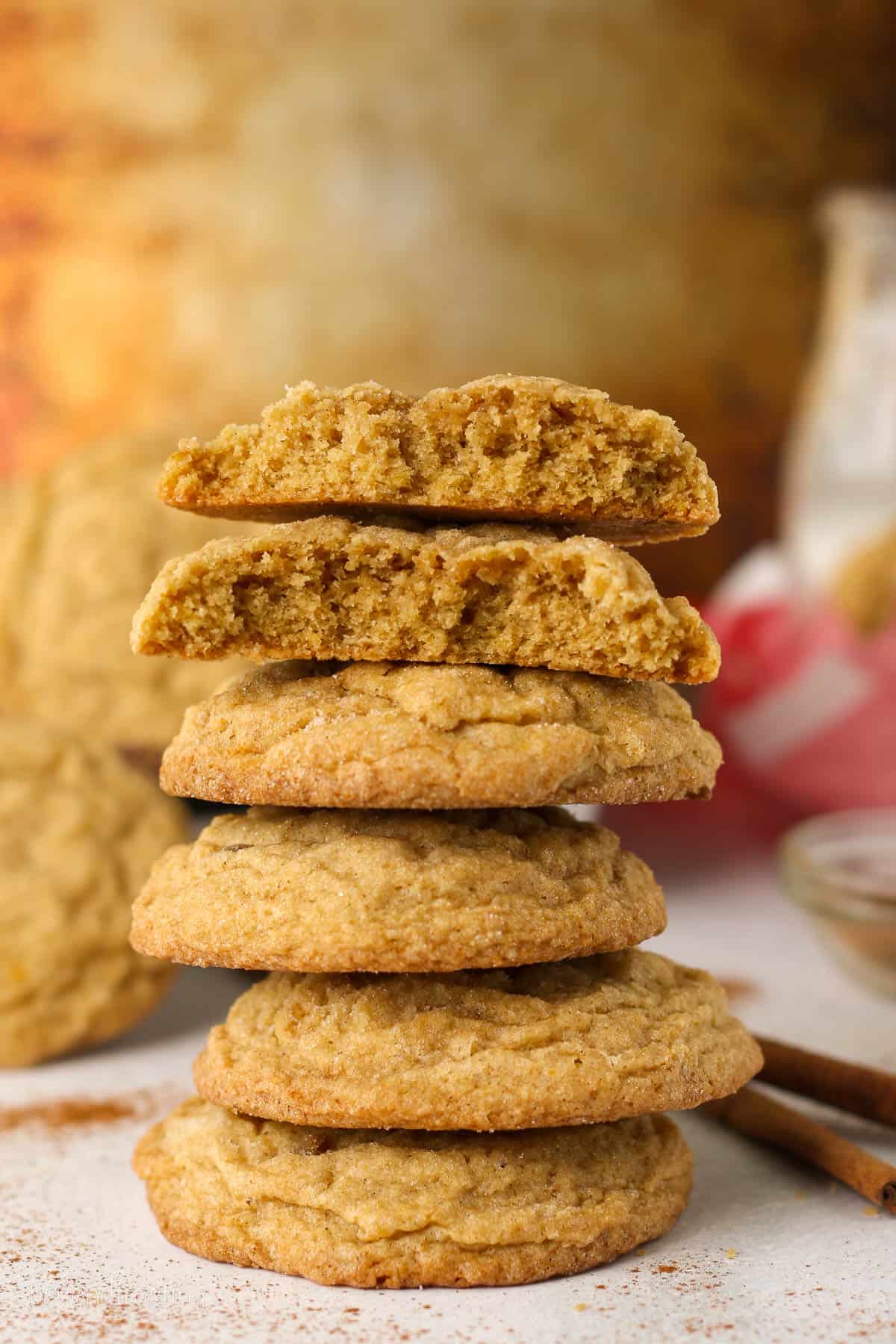 A tall stack of pumpkin sugar cookies on a countertop.