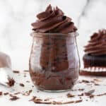 Whipped ganache frosting piped in a glass jar.