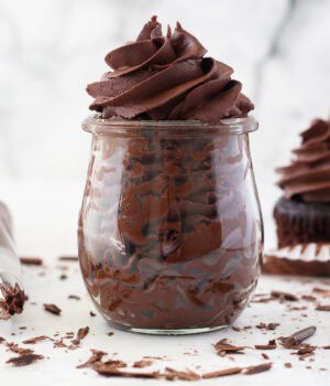 Whipped ganache frosting piped in a glass jar.