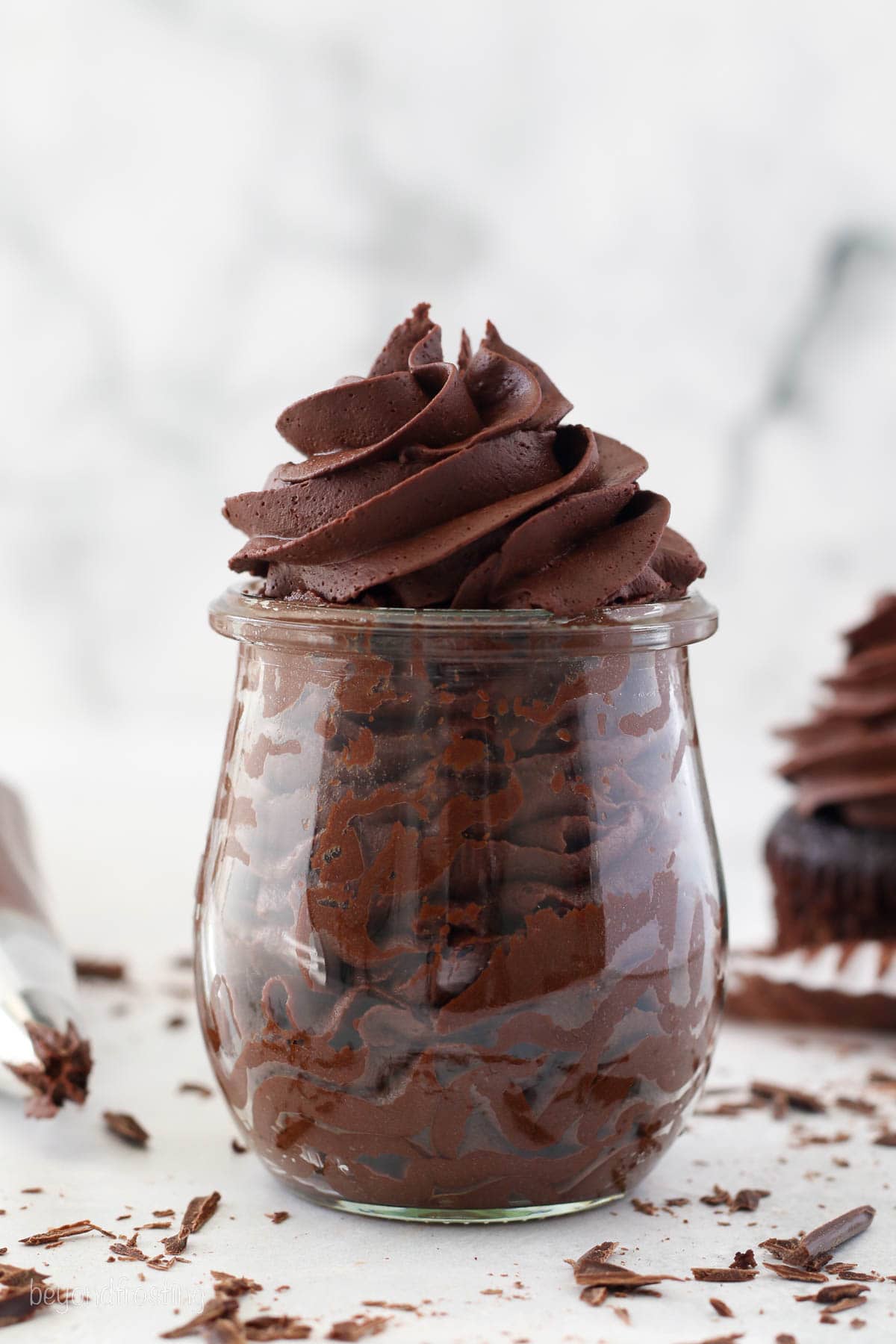 Whipped ganache frosting piped in a glass jar.