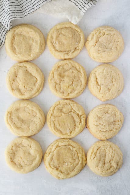 Overhead view of three rows of sugar cookies, showing the differences when baked with cream of tartar, lemon juice, or baking powder.