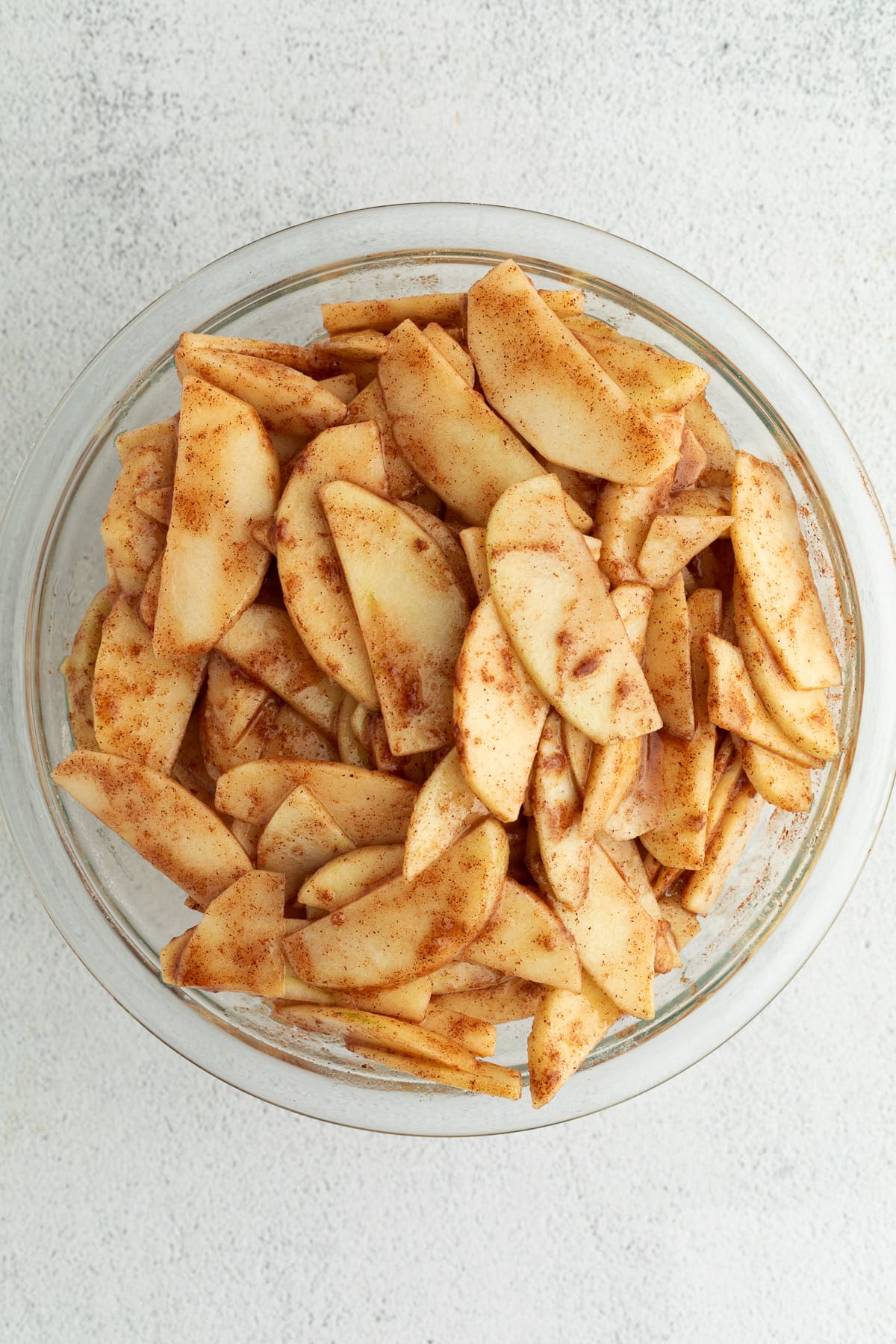 Cinnamon apple pie filling in a glass bowl.