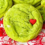Close up of a grinch cookie garnished with a red heart sprinkle.
