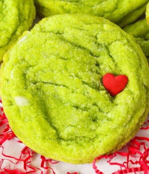 Close up of a grinch cookie garnished with a red heart sprinkle.