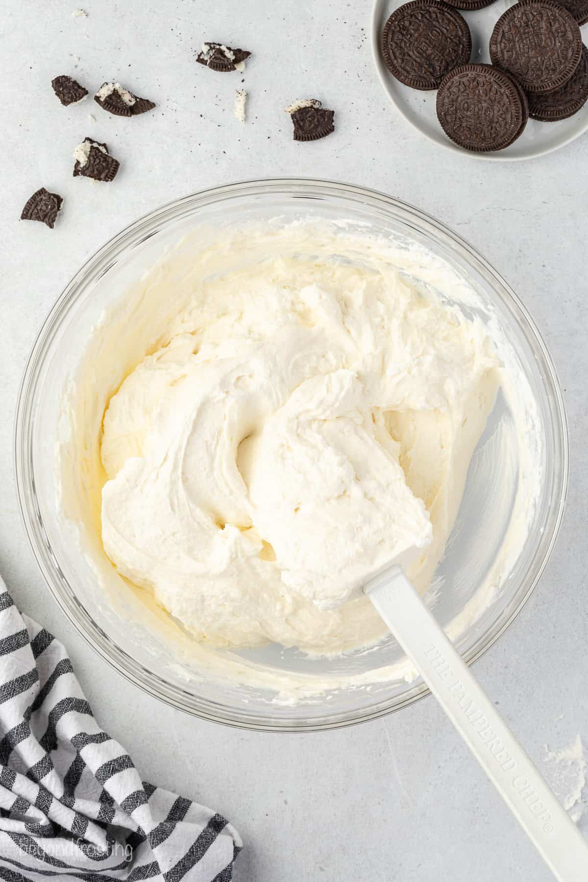 mixed no-bake cheesecake batter in a glass mixing bowl